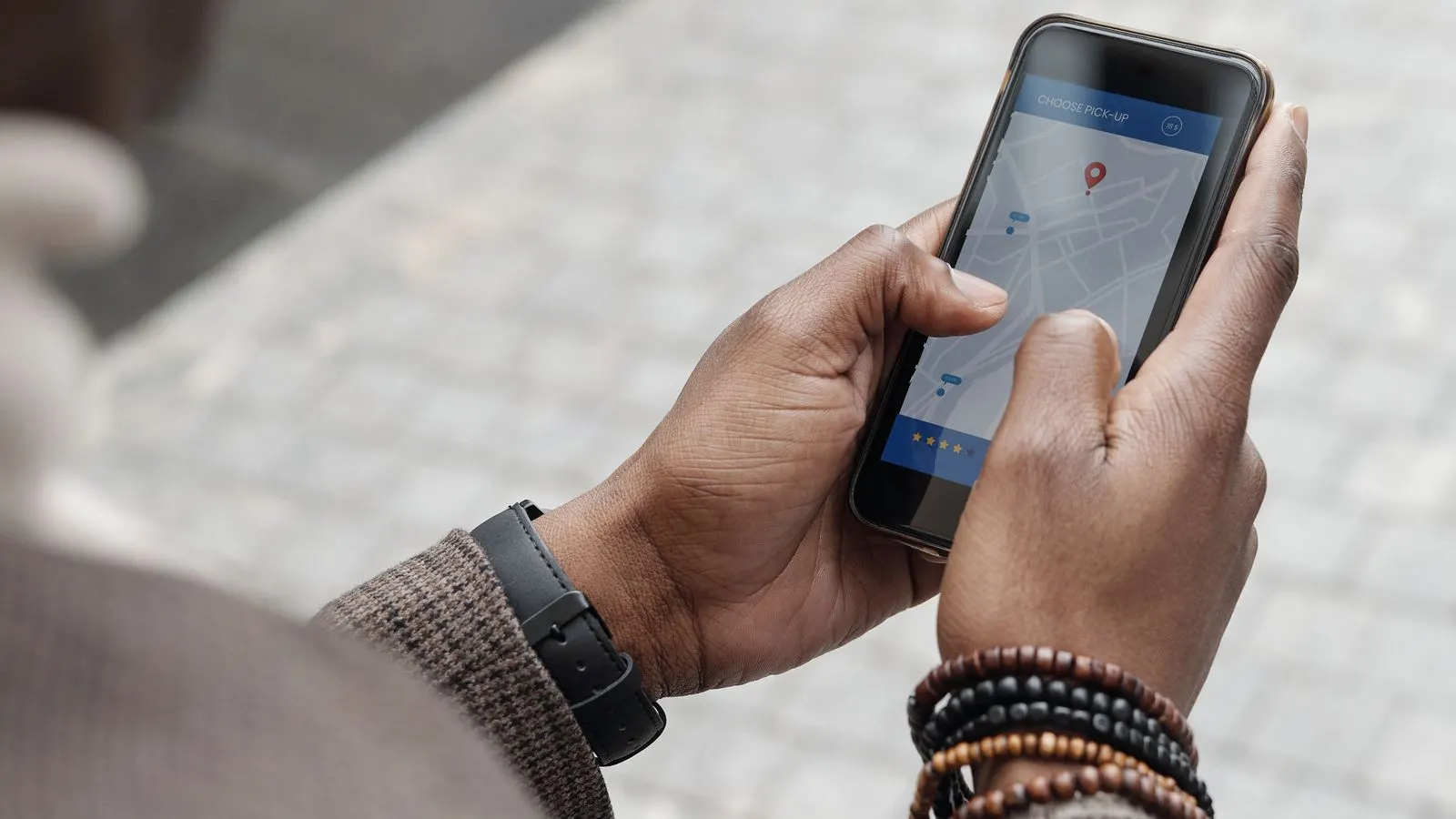A person's hands holding a phone showing a map app with a location pin
